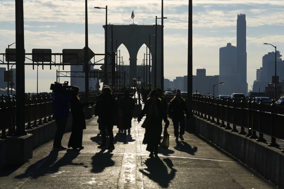 Pedestrians walk on the Brooklyn Bridge in New York, Wednesday, Jan. 3, 2024. New York City has banned vendors from the Brooklyn Bridge starting Wednesday. The move is intended to ease overcrowding on the famed East River crossing, where dozens of souvenir sellers competed for space with tourists and city commuters. (AP Photo/Seth Wenig)