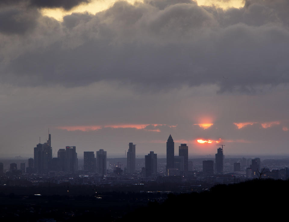 The sun rises between clouds over the banking district of Frankfurt, Germany, Tuesday, Jan. 8, 2019. (AP Photo/Michael Probst)
