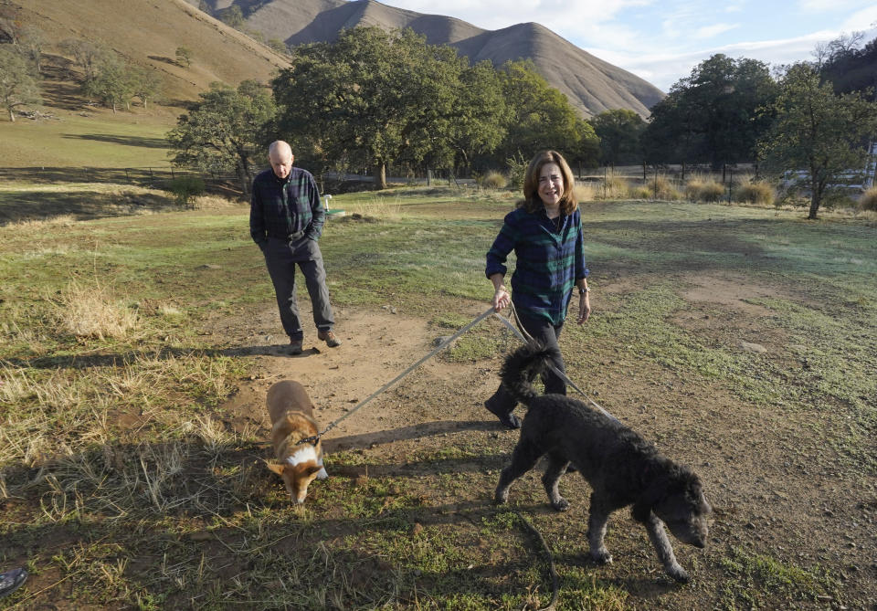 Former California Gov. Jerry Brown and his wife, Anne Gust Brown take their dogs, Colusa, left, and Cali, right, for a walk at their ranch near Williams, Calif., Saturday, Oct. 30, 2021. (AP Photo/Rich Pedroncelli)