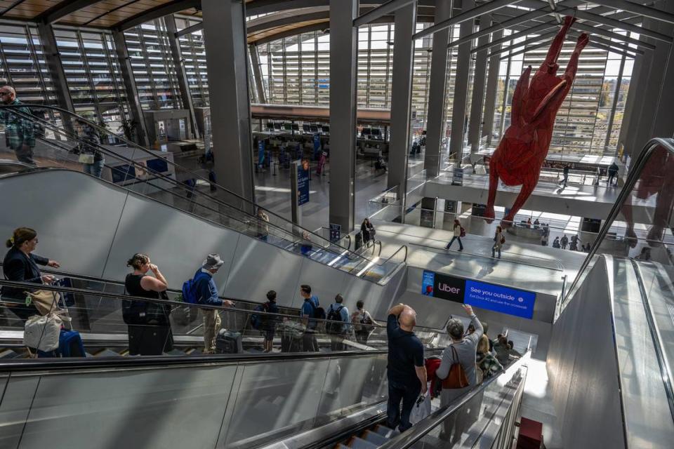 Viajeros descienden por las escaleras mecánicas hacia el área de recolección de equipajes en la Terminal B del Aeropuerto Internacional de Sacramento el 22 de noviembre de 2023, víspera de Acción de Gracias.