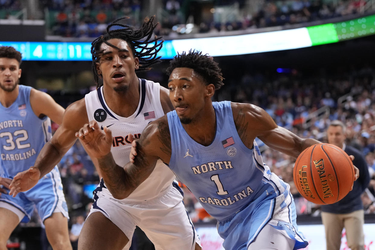 Mar 9, 2023; Greensboro, NC, USA; North Carolina Tar Heels forward Leaky Black (1) drives as Virginia Cavaliers guard Armaan Franklin (4) defends in the first half of the quarterfinals of the ACC tournament at Greensboro Coliseum.  Mandatory Credit: Bob Donnan-USA TODAY Sports