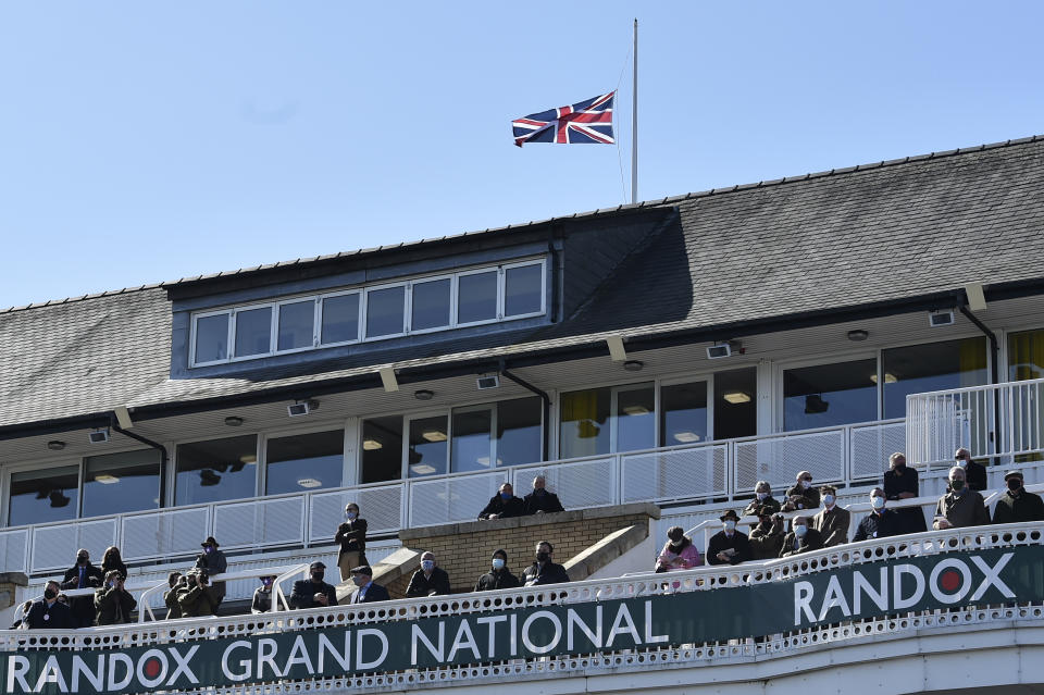 The Union Jack flies at half mast behind the stands in honour of the late Prince Philip, Duke of Edinburgh, during races on the second day of the Grand National Horse Racing meeting at Aintree racecourse, near Liverpool, England, Friday April 9, 2021. (Peter Powell/Pool via AP)