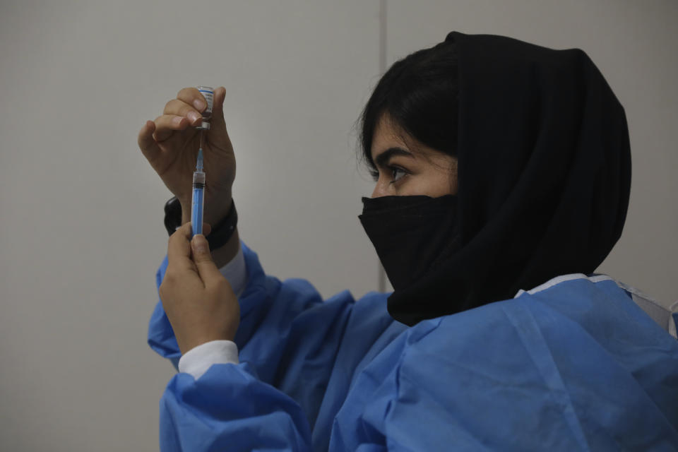 A health worker prepares a shot of Covid-19 vaccine for a citizen at a vaccination center in Iran Mall shopping center in Tehran, Iran, Monday, Aug. 9, 2021. Iran — like much of the world — remains far behind countries like the United States in vaccinating its public. So far only 3 million people out of Iran's population of 80 million have had both vaccine doses. (AP Photo/Vahid Salemi)