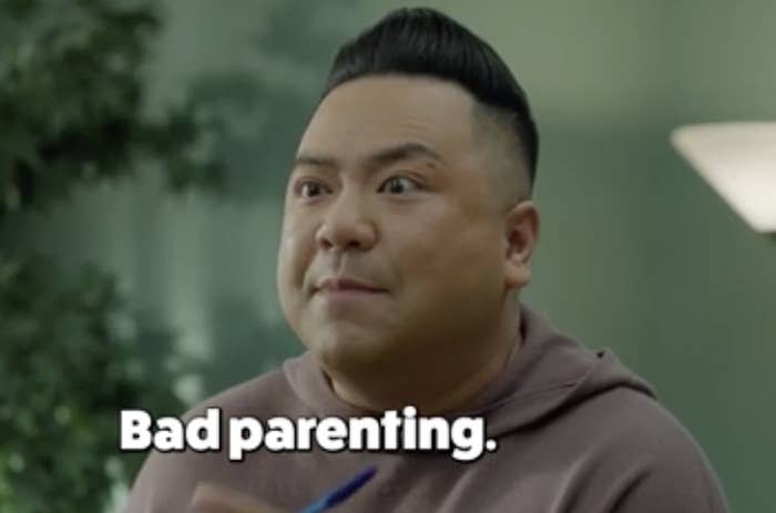 Image of actor Andrew Phung on "Run The Burbs," holding a pen, with the text "Bad parenting." in white letters