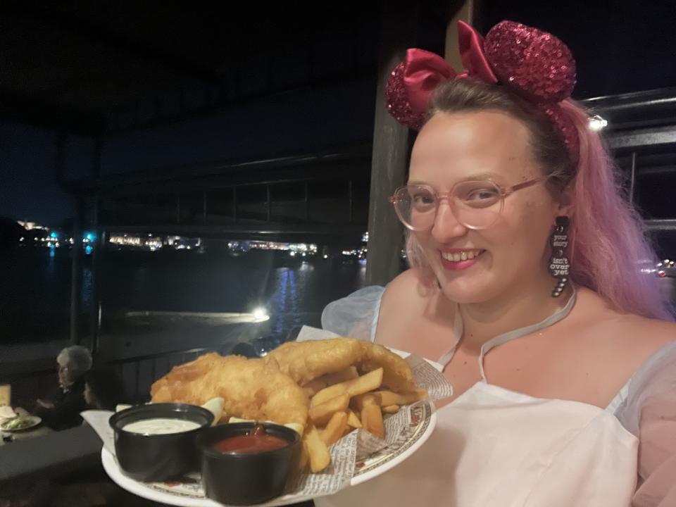 Author holding plate of fish and chips.