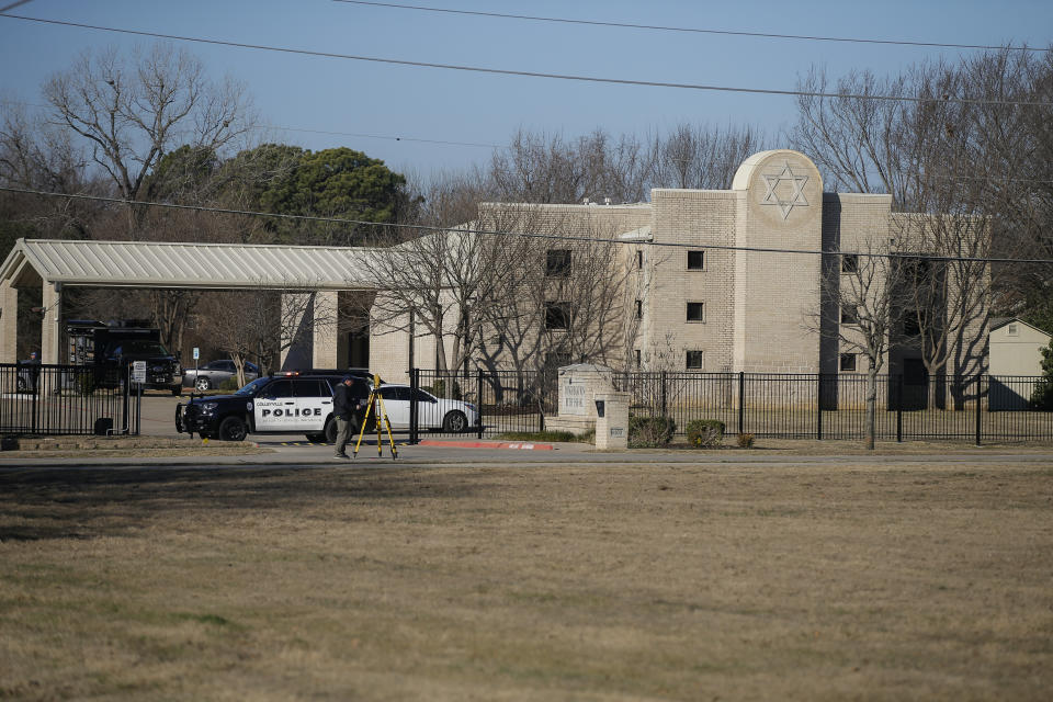 Law enforcement process the scene in front of the Congregation Beth Israel synagogue, Sunday, Jan. 16, 2022, in Colleyville, Texas. A man held hostages for more than 10 hours Saturday inside the temple. The hostages were able to escape and the hostage taker was killed. FBI Special Agent in Charge Matt DeSarno said a team would investigate "the shooting incident." (AP Photo/Brandon Wade)