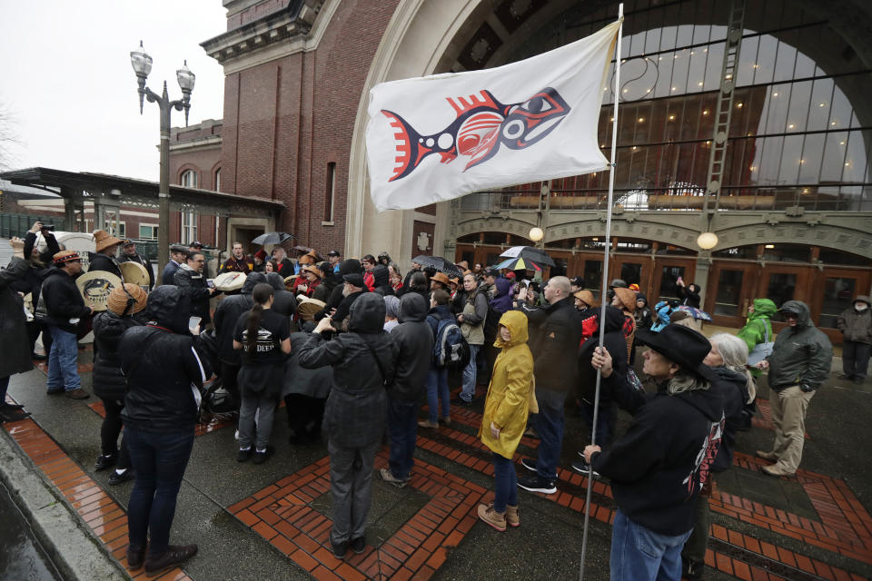 FILE - In this Jan. 6, 2020, file photo, the flag of the Chinook Indian Nation is displayed in the wind as tribal members and other supporters gather outside the federal courthouse in Tacoma, Wash., as they continue their efforts to regain federal recognition. As COVID-19 disproportionately affects Native American communities, many tribal leaders say the pandemic poses particular risks to tribes without federal recognition. (AP Photo/Ted S. Warren, File)