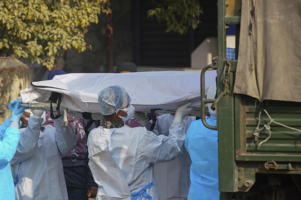 Medical personnel load the body of a victim onto a truck to be transported to Kathmandu, in Pokhara, Nepal, Tuesday, Jan 17, 2023. Nepalese authorities on Tuesday began returning to families the bodies of victims of a flight that crashed Sunday, and said they were sending the aircraft's data recorder to France for analysis as they try to determine what caused the country's deadliest plane accident in 30 years. (AP Photo/Yunish Gurung)