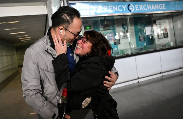 Un pareja se abraza en un aeropuerto de China.