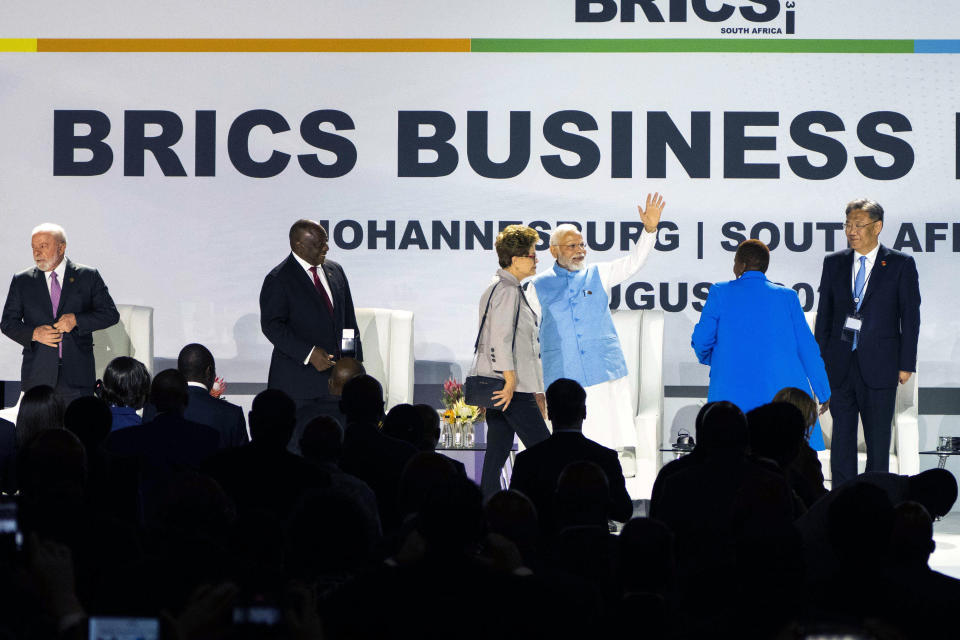 Indian Prime Minister Narendra Modi waves at the start of the BRICS group of emerging economies three-day summit in Johannesburg, South Africa, Tuesday, Aug. 22, 2023. From left, Brazilian President Luiz Inácio Lula da Silva, South African President Cyril Ramaphosa , Modi and China minister of commerce Wang Wentao. They will be joined by Russian President Vladimir Putin who will appear on a video link after his travel to South Africa was complicated by an International Criminal Court arrest warrant against him over the war in Ukraine. (AP Photo/Jerome Delay)