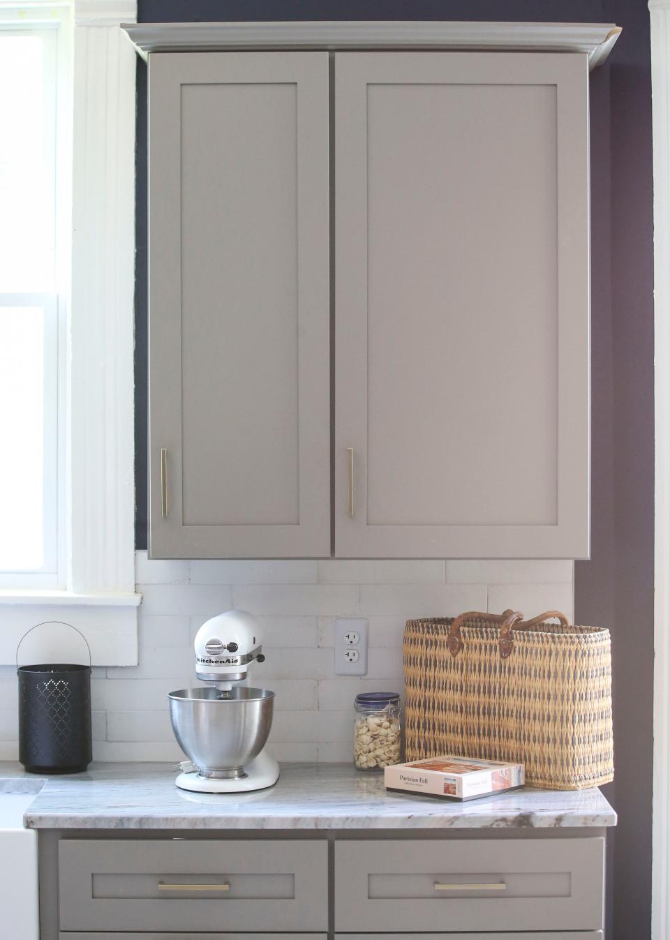 Because the walls are such a vibrant hue, Courier Journal dining columnist Dana McMahan and business partner Michael Downey kept sophisticated whites and greys in the rest of the kitchen, like the distressed subway tiles from Ragno (from Louisville Tile).