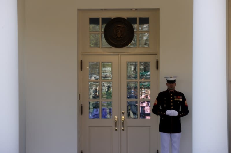 A U.S. Marine stands at the door of the West Wing, where President Donald Trump held meetings throughout the day via phone on the coronavirus response, at the White House in Washington