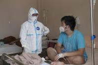 Dr. Irman Pahlepi, left, treats a COVID-19 patient at the Dr. Suyoto General Hospital in Jakarta, Indonesia, on July 29, 2021. Pahlepi is back at work in the hospital, immediately resuming his duties treating COVID-19 patients after recovering from an infection himself, for the second time. With numbers of infections in Indonesia skyrocketing and deaths steadily climbing, health care workers are being depleted as the virus spares nobody, Pahlepi felt he had no option but to jump right back in. (AP Photo/Tatan Syuflana)