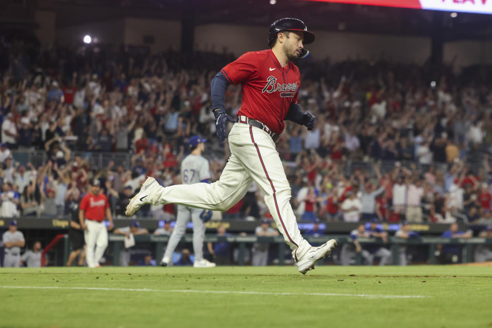 Atlanta Braves' Travis d'Arnaud heads toward first after hitting a grand slam against the Texas Rangers during the sixth inning of a baseball game Friday, April 19, 2024, in Atlanta. (Jason Getz/Atlanta Journal-Constitution via AP)