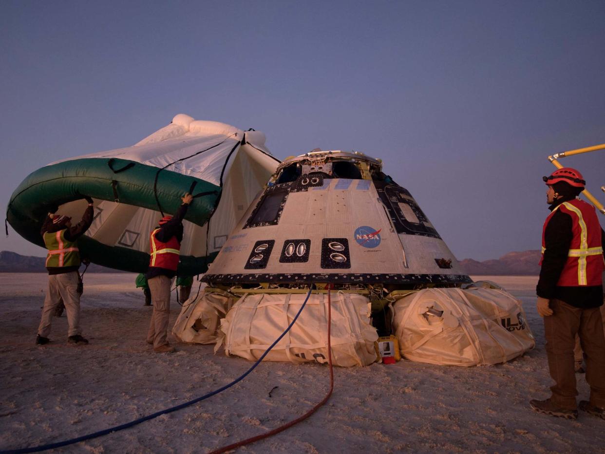 Boeing, NASA, and US Army personnel work around the Boeing Starliner spacecraft shortly after it landed in White Sands, New Mexico, 22 December, 2019: Bill Ingalls/NASA via AP