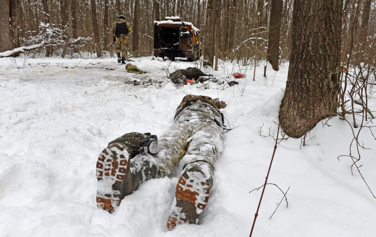 <span class="caption">The body of a serviceman near a destroyed Russian military vehicle.</span> <span class="attribution"><a class="link " href="https://www.gettyimages.com/detail/news-photo/graphic-content-topshot-a-photograph-taken-on-march-7-2022-news-photo/1239020055?adppopup=true" rel="nofollow noopener" target="_blank" data-ylk="slk:Sergey Bobok/AFP via Getty Images;elm:context_link;itc:0;sec:content-canvas">Sergey Bobok/AFP via Getty Images</a></span>