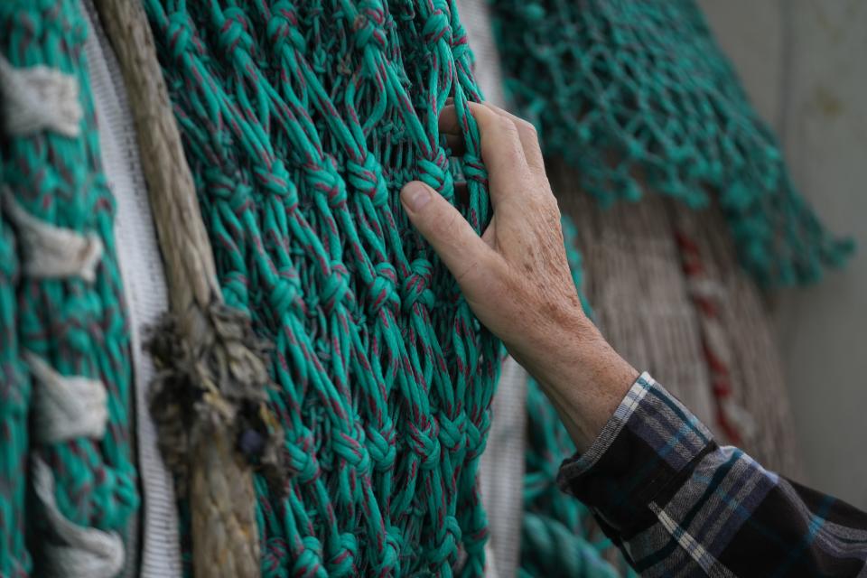 Bill Bright shows a net used to fish herring off Cape May, N.J. The industry is fighting a federal regulation at the Supreme Court.