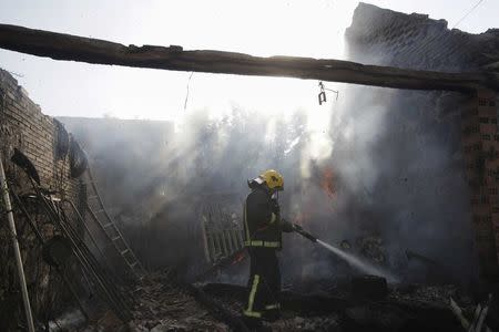 A fireman sprays water inside a destroyed house after an explosion in a fireworks storage facility in Paramos, Spain, May 23, 2018. REUTERS/Miguel Vidal