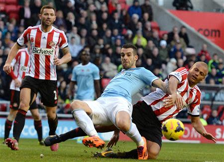 Manchester City's Alvaro Negredo (C) is challenged by Sunderland's Wes Brown during their English Premier League soccer match at The Stadium of Light in Sunderland, northern England, November 10, 2013.