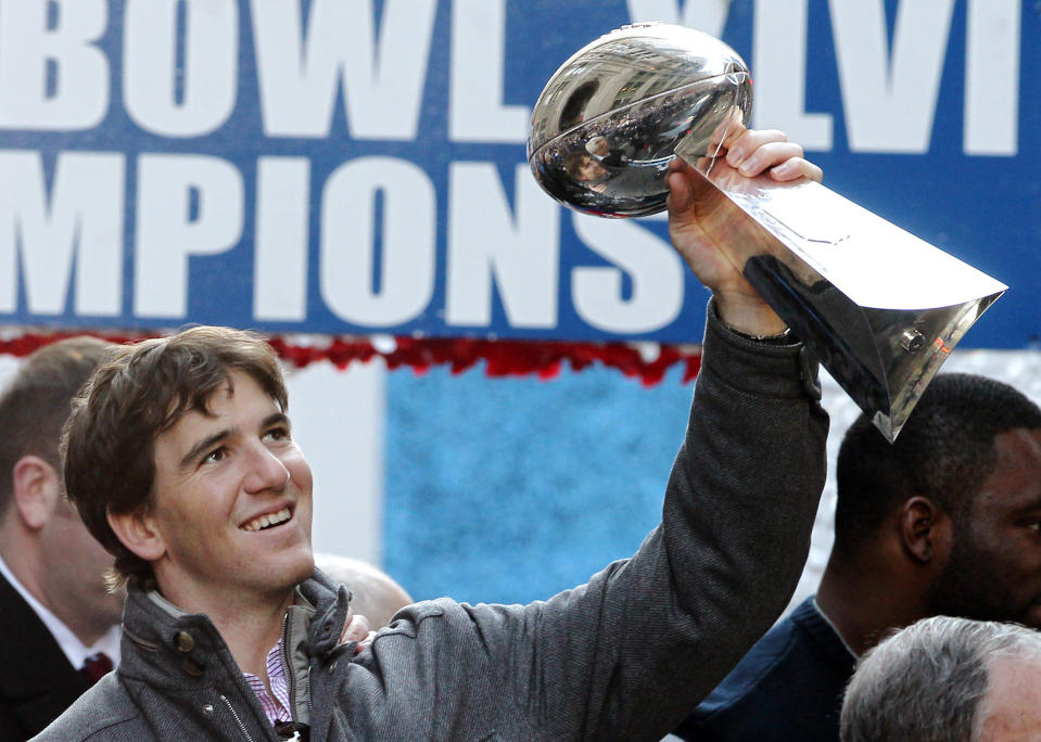 In this Feb. 7, 2012 file photo New York Giants quarterback Eli Manning holds up the Vince Lombardi Trophy during the team's NFL football Super Bowl parade in New York. Manning, who led the Giants to two Super Bowls in a 16-year career that saw him set almost every team passing record, has retired. The Giants said Wednesday, Jan. 22, 2020 that Manning would formally announce his retirement on Friday. (AP Photo/Julio Cortez, file)