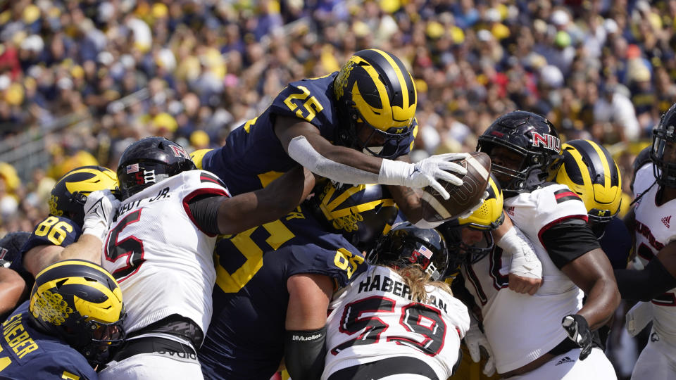 Michigan running back Hassan Haskins (25) dives over the line for a one-yard touchdown run against Northern Illinois in the first half of a NCAA college football game in Ann Arbor, Mich., Saturday, Sept. 18, 2021. (AP Photo/Paul Sancya)