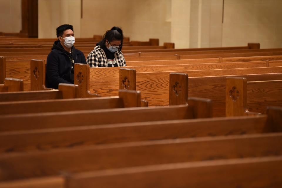 Two members of the congregation are seen as Rev. Msgr. Richard J. Arnhols leads an evening service at St. John the Evangelist in Bergenfield, Monday night on 11/15/21.