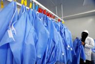 A woman hangs coats in a factory that produces sterilised surgical equipment and medical clothings in Egypt