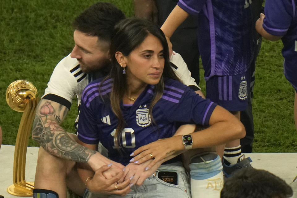 Argentina's Lionel Messi sits with his wife Antonela Roccuzzo after Argentina won the World Cup final soccer match against France at the Lusail Stadium in Lusail, Qatar, Sunday, Dec. 18, 2022. (AP Photo/Francisco Seco)