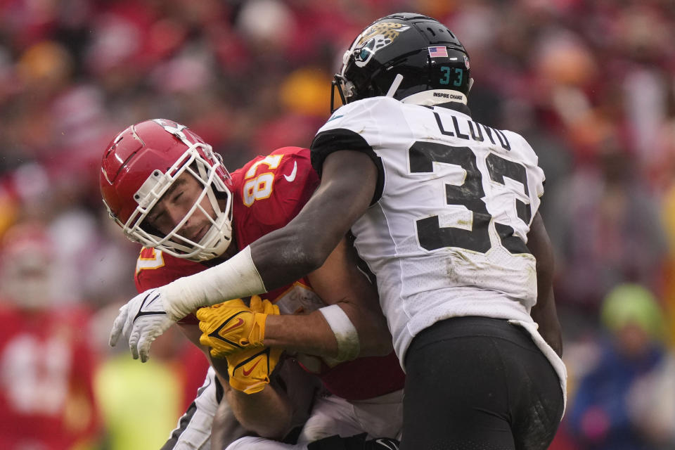 Jacksonville Jaguars linebacker Devin Lloyd (33) hits Kansas City Chiefs tight end Travis Kelce (87) during the first half of an NFL divisional round playoff football game, Saturday, Jan. 21, 2023, in Kansas City, Mo. (AP Photo/Charlie Riedel)