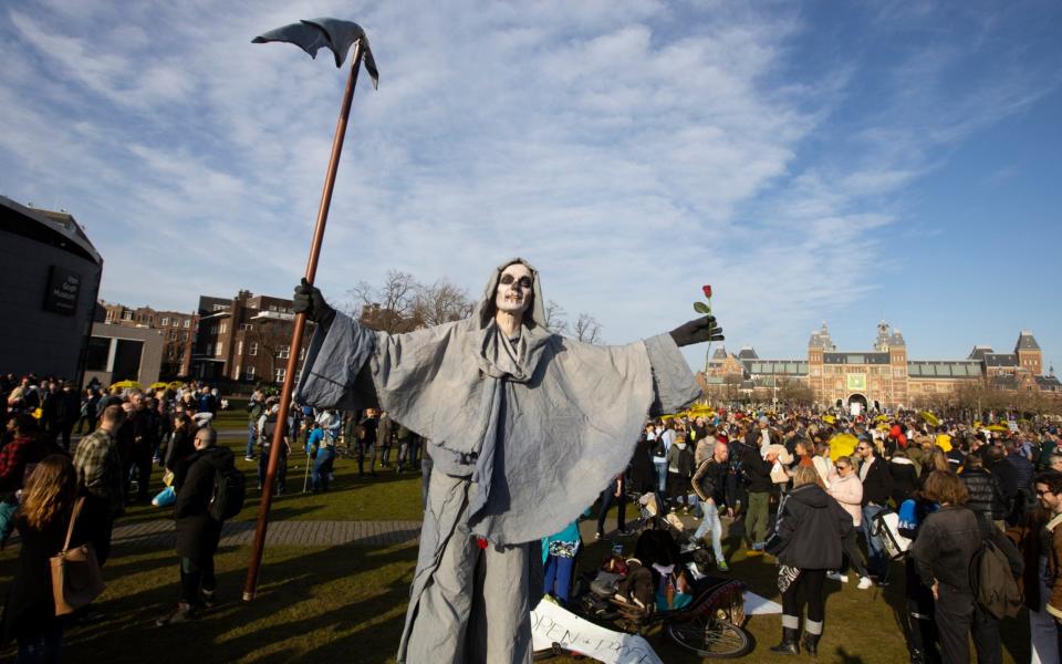 A person dressed as the grim reaper takes part in a demonstration of several hundreds of people against the lockdown and curfew in Amsterdam,  - Peter Dejong/AP