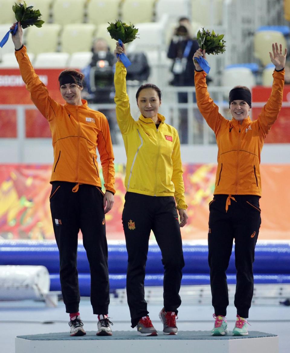 From left to right, Bronze medallist Margot Boer of the Netherlands, gold medallist China's Zang Hong, and silver medallist Ireen Wust of the Netherlands celebrate during the flower ceremony for the women's 1,000-meter speedskating race at the Adler Arena Skating Center during the 2014 Winter Olympics in Sochi, Russia, Thursday, Feb. 13, 2014. (AP Photo/David J. Phillip )