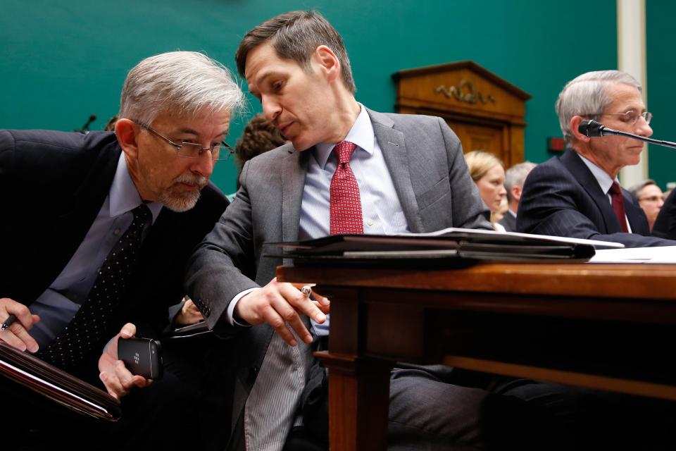 Centers for Disease Control and Prevention Director Tom Frieden (C) speaks with a staff member as he and National Institute of Allergy and Infectious Disease Director Anthony Fauci (R) testify before a House Energy and Commerce Oversight and Investigations Subcommittee hearing on the U.S. response to the Ebola crisis, in Washington October 16, 2014. REUTERS/Jonathan Ernst (UNITED STATES - Tags: POLITICS HEALTH)