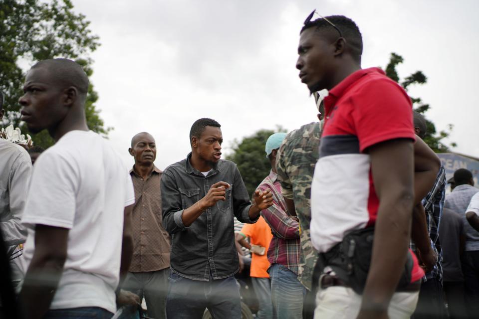 Congolese supporters of UDPS presidential candidate Felix Tshisekedi stand outside his party headquarters in Kinshasa, Congo, Tuesday Jan. 8, 2019, to participate in a general boxing and martial arts competition. As Congo anxiously awaits the outcome of the presidential election, many in the capital say they are convinced that the opposition won and that the delay in announcing results is allowing manipulation in favor of the ruling party. (AP Photo/Jerome Delay)