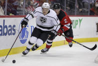 Los Angeles Kings center Blake Lizotte (46) controls the puck in front of New Jersey Devils defenseman Colton White during the first period of an NHL hockey game Sunday, Jan. 23, 2022, in Newark, N.J. (AP Photo/Adam Hunger)