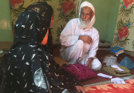 An Afghan refugee talks to family members as EU officials and aid workers visit his home in Kerman, Iran, October 23, 2016. REUTERS/Gabriela Baczynska