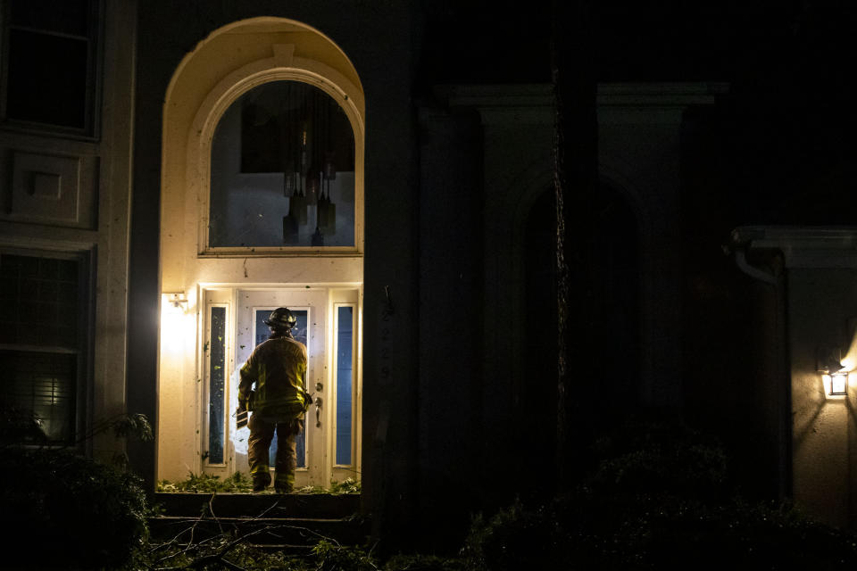 A firefighter checks on a home damaged by a storm that rolled through the Great Neck area of Virginia Beach, Va., on Sunday, April 30, 2023. (Kendall Warner/The Virginian-Pilot via AP)