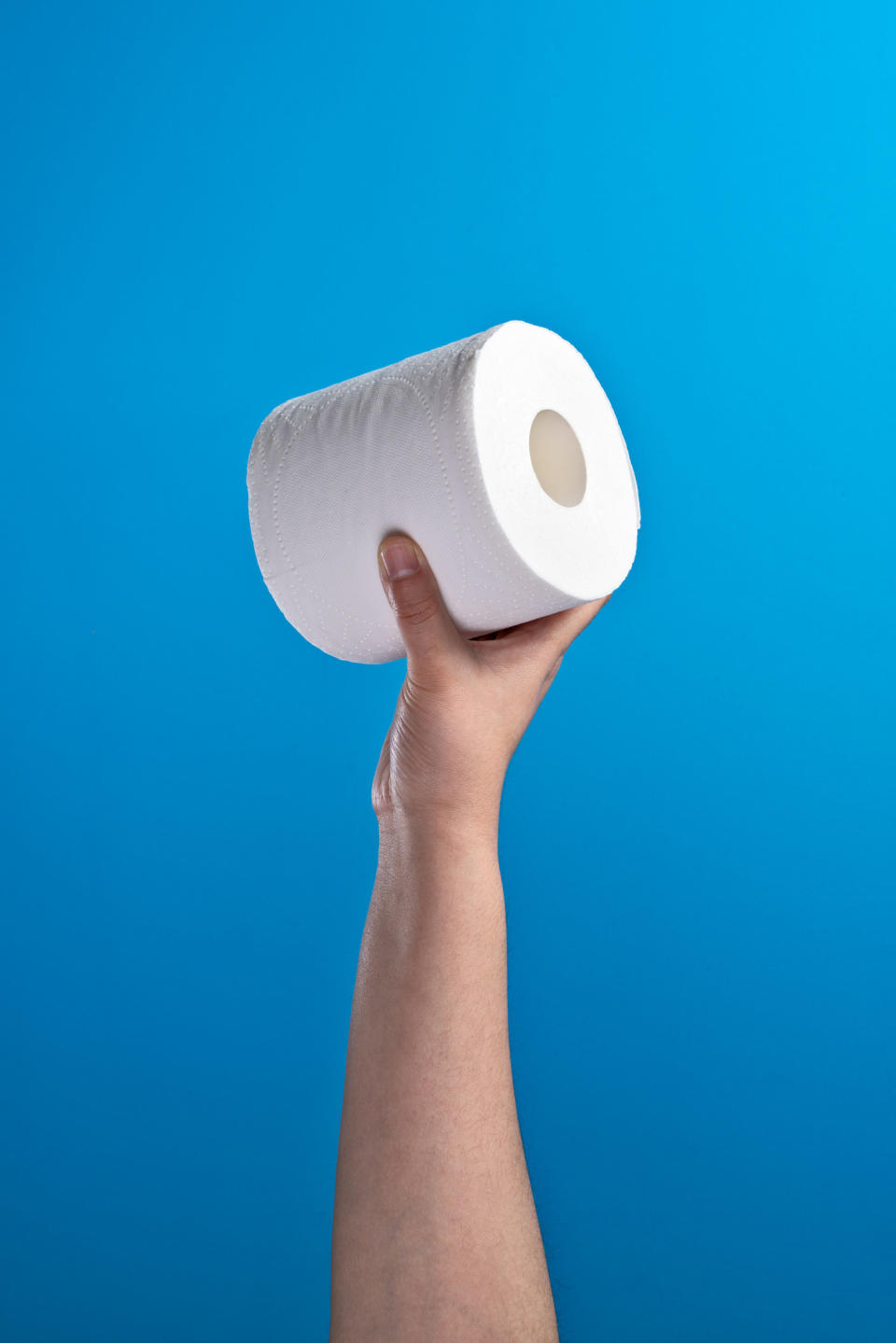 a hand holding up toilet paper