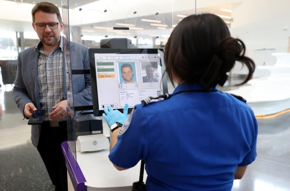 Marcus Hardy, Intrepid public relations account director, and Denise Torres, TSA supervisory transportation security officer, demonstrate how to use next-generation credential authorization technology units at the Salt Lake City International Airport in Salt Lake City, on Thursday.