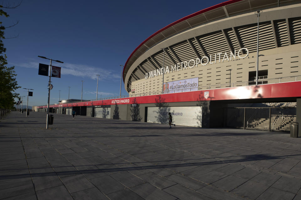 Un hombre trota frente al estadio del Atlético de Madrid, el martes 5 de mayo de 2020. (AP Foto/Paul White).