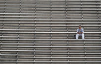 FILE - In this Nov. 17, 2012, file photo, an Arizona State fan is all alone in the upper deck during an NCAA college football game against Washington State, in Tempe, Ariz. As lock-downs are lifted, restrictions on social gatherings eased and life begins to resemble some sense, sports are finally starting to emerge from the coronavirus pandemic. Many college and pro sports teams already were dealing with declining ticket sales. The improved at-home experience, the emergence of wide-spread legalized betting and the changing social makeup of fan bases have been catalysts, while dynamic pricing, increases in parking and concession prices and a push toward luxury seating have exacerbated the problem.(AP Photo/Ross D. Franklin, File)