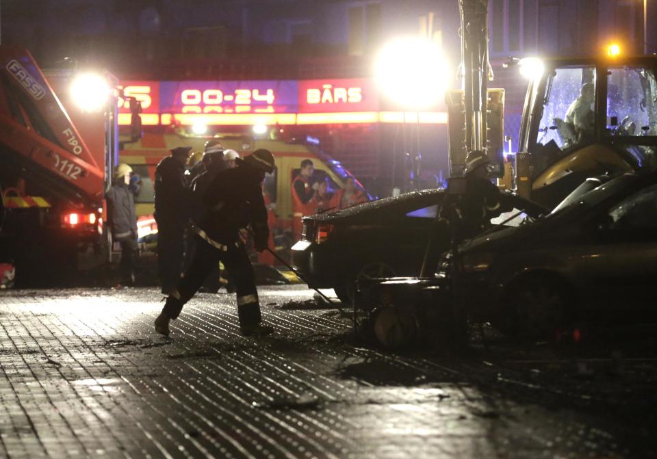 Firefighters work near a store with a collapsed roof in Riga