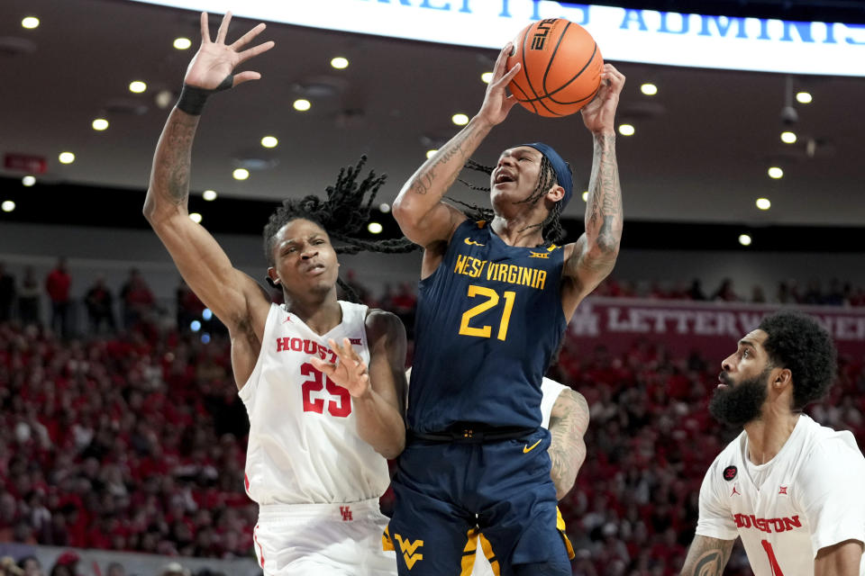 West Virginia guard RaeQuan Battle (21) shoots as Houston forward Joseph Tugler, left, defends during the second half of an NCAA college basketball game Saturday Jan. 6, 2024, in Houston. (AP Photo/Eric Christian Smith)