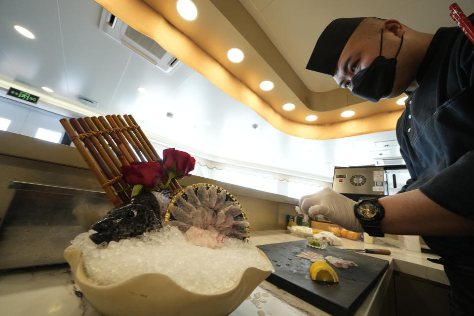 A chef prepares spotted knifejaw sashimi caught from a rearing pen at the Genghai No. 1 facility along the coastline of Yantai in eastern China's Shandong province on Tuesday, Aug. 22, 2023. (AP Photo/Ng Han Guan)