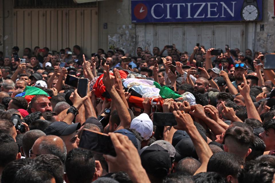 Mourners carry the body of Palestinian commander of the Al-Aqsa Martyrs' Brigade Ibrahim al-Nabulsi, who was killed in an Israeli raid, during his funeral procession in the West Bank city of Nablus on August 9, 2022. - Three people were killed and dozens wounded, the Palestinian health ministry said, as Israeli forces raided the occupied West Bank city of Nablus. The latest violence comes two days after deadly fighting between Israel and Islamic Jihad militants in the coastal enclave of Gaza was halted by a truce. (Photo by ABBAS MOMANI / AFP) (Photo by ABBAS MOMANI/AFP via Getty Images)