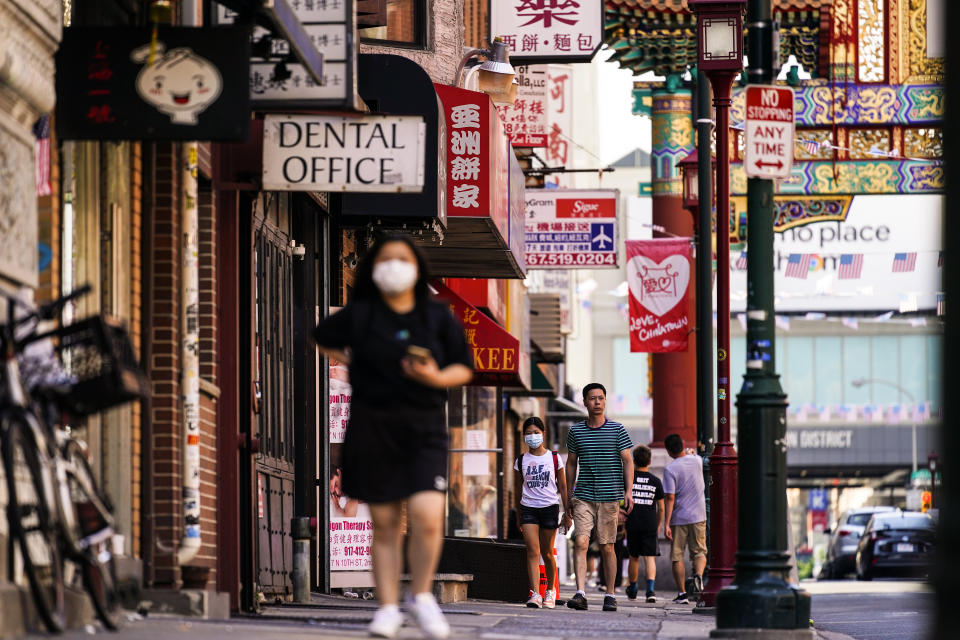 Pedestrians walk along 10th Street in the Chinatown neighborhood of Philadelphia, Friday, July 22, 2022. Organizers and members of Philadelphia's Chinatown say they were surprised by the 76ers' announcement that they hope to build a $1.3 billion arena just a block from the community’s gateway arch. (AP Photo/Matt Rourke)