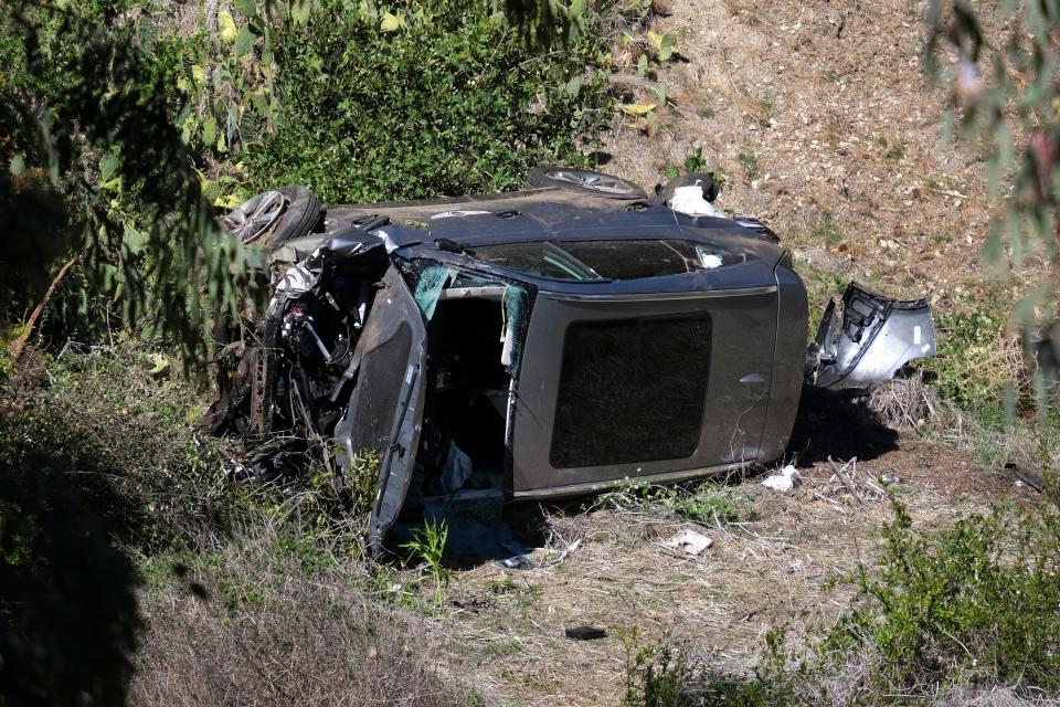 A vehicle rests on its side after a rollover accident involving golfer Tiger Woods along a road in the Rancho Palos Verdes section of Los Angeles on Tuesday, Feb. 23, 2021. Woods suffered leg injuries in the one-car accident and was undergoing surgery, authorities and his manager said.