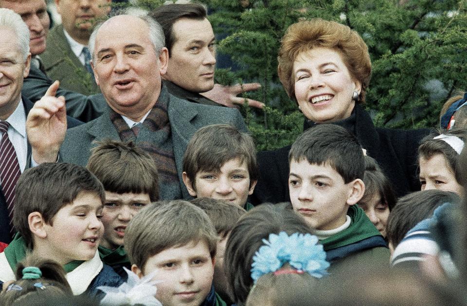 FILE - Soviet leader Mikhail Gorbachev with his wife Raisa pose with a group of young Yugoslavian school children after they attended a tree planting ceremony at the Park of Friendship near Belgrade, March 15, 1988. The Soviet pair are on an official visit to Yugoslavia. When Mikhail Gorbachev is buried Saturday at Moscow's Novodevichy Cemetery, he will once again be next to his wife, Raisa, with whom he shared the world stage in a visibly close and loving marriage that was unprecedented for a Soviet leader. Gorbachev's very public devotion to his family broke the stuffy mold of previous Soviet leaders, just as his openness to political reform did. (AP Photo, File)