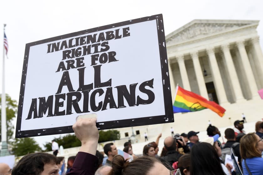 FILE - In this Oct. 8, 2019, file photo, protesters gather outside the Supreme Court in Washington where the Supreme Court is hearing arguments in the first case of LGBT rights since the retirement of Supreme Court Justice Anthony Kennedy. As vice president in 2012, Joe Biden endeared himself to many LGBTQ Americans by endorsing same-sex marriage even before his boss, President Barack Obama. Now, as president-elect, Biden is making sweeping promises to LGBTQ activists, proposing to carry out virtually every major proposal on their wish lists. (AP Photo/Susan Walsh, File)