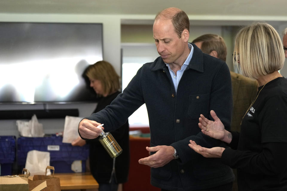 Britain's Prince William is shown items by Claire Hopkins, Operations Director, right, during a visit to Surplus to Supper, in Sunbury-on-Thames, Surrey, England, Thursday, April 18, 2024. The Prince visited Surplus to Supper, a surplus food redistribution charity, to learn about its work bridging the gap between food waste and food poverty across Surrey and West London. (AP Photo/Alastair Grant, pool)