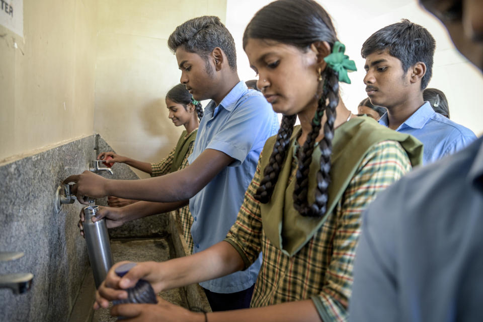 Estudiantes reciben agua en una escuela pública de Bengaluru, India, el 18 de marzo de 2024. (Atul Loke/The New York Times)
